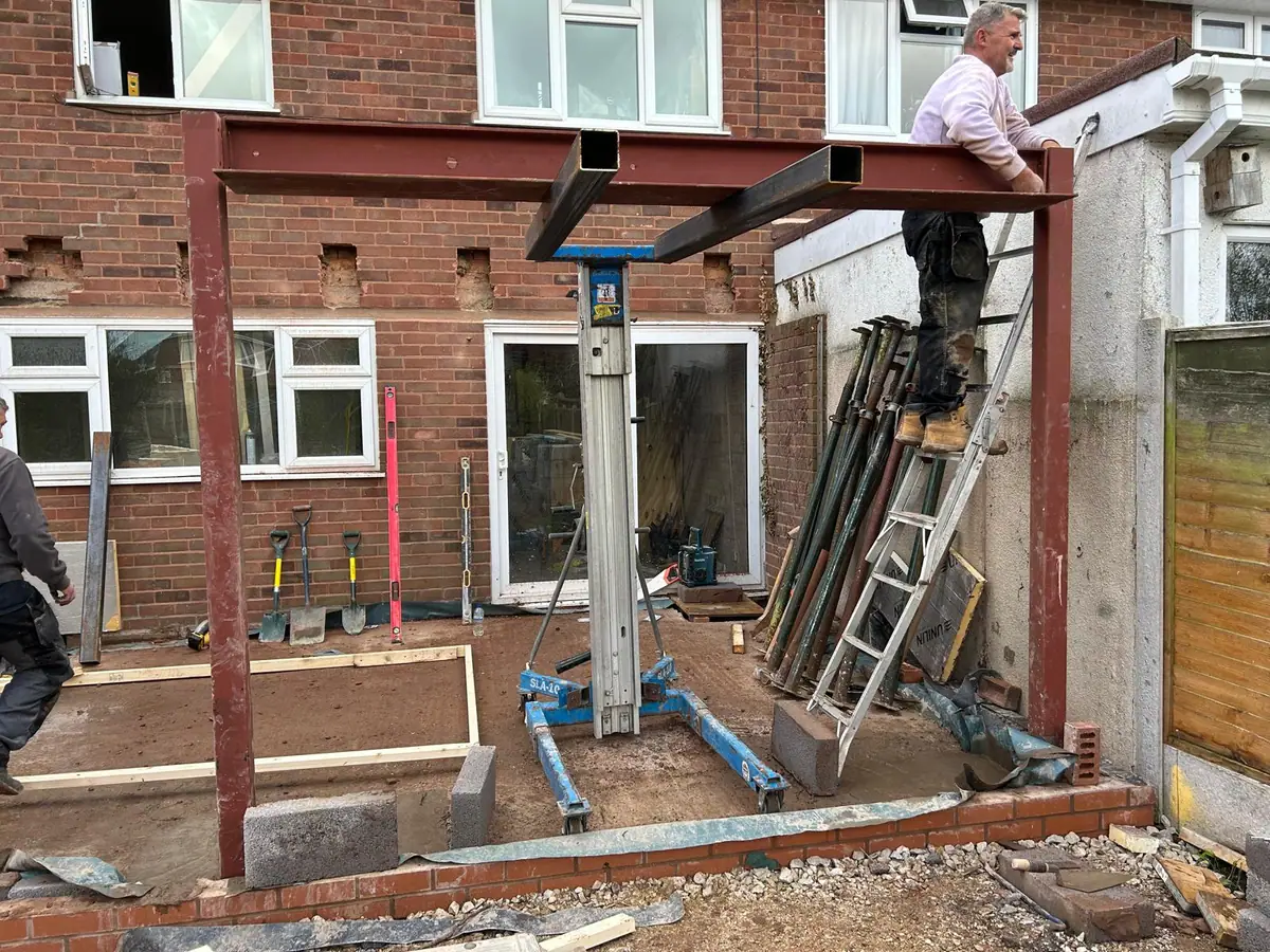 Structural steel goalpost frame being erected at the rear of a house in Wombourne