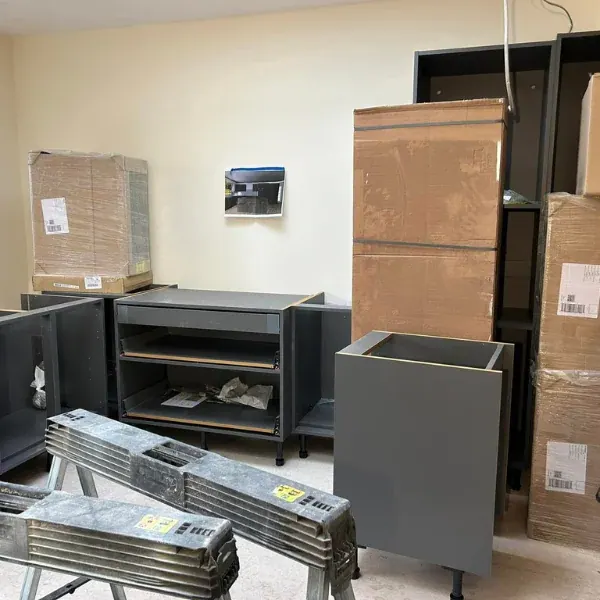 Grey kitchen base units and boxed units waiting to be fitted in a new extension