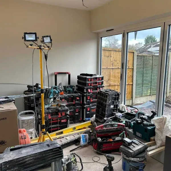 Extension interior with bi-fold doors onto the garden, with tools and equipment during fit-out